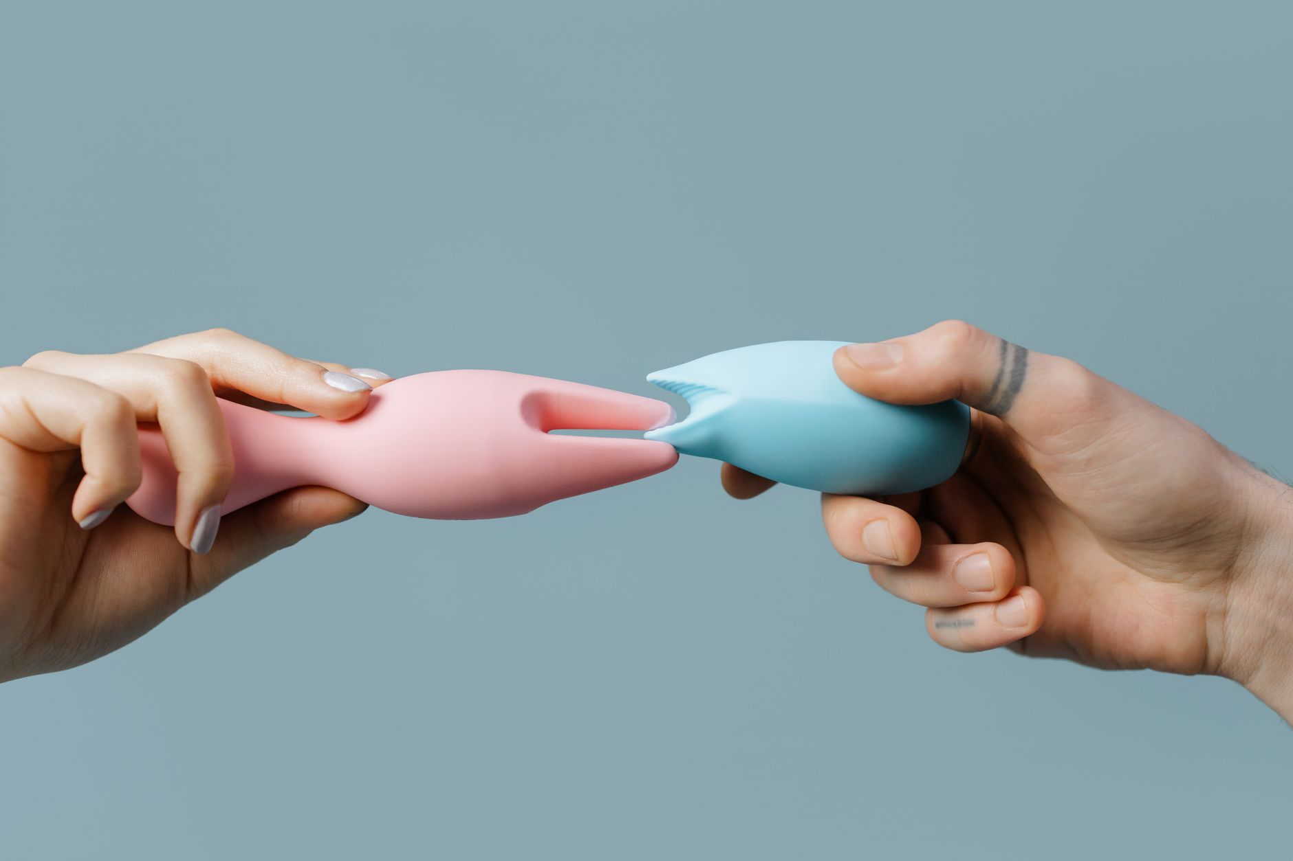 Vibrant collection of colorful clitoral vibrators arranged on a bright yellow surface
