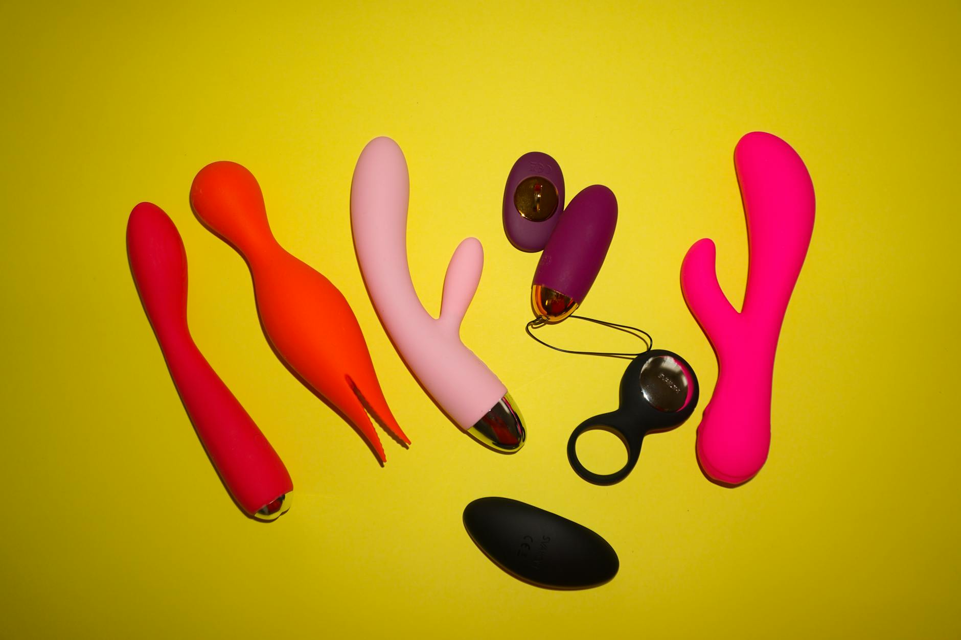 A person holding a basket containing colorful vibrators and a pink flower.